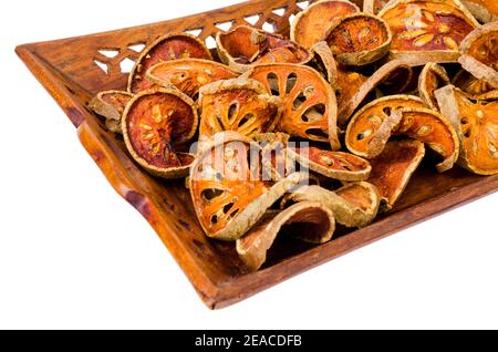 Holztablett mit getrockneten Bael Obst isoliert auf weißem Hintergrund. Studio Foto Stockfoto