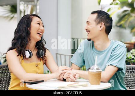 Lachendes Paar am Kaffeetisch Stockfoto