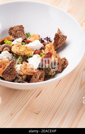 Salat mit Croutons und gegrilltem Hähnchen auf weißem Teller Stockfoto