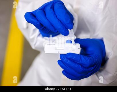 Köln, Nordrhein-Westfalen, Deutschland - Covid-Schnelltest in einer Parkgarage im Medicare-Testzentrum fahren Kunden zum Einfahrschalter im Auto, um Proben zu nehmen, das Wattestäbchen wird dann in eine Trägerlösung gegeben, die dann auf einen Teststreifen aufgetragen wird. Stockfoto