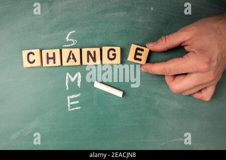 Änderung und gleiches Konzept. Der Text aus den Buchstaben des hölzernen Alphabets auf dem grünen Kreidetafel. Stockfoto