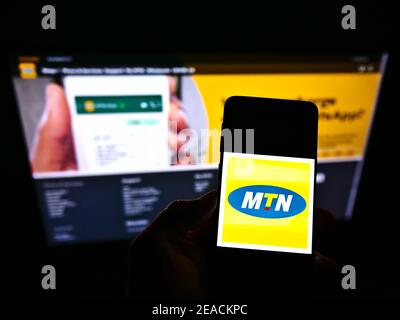 Person, die Smartphone mit Logo des südafrikanischen Telekommunikationsunternehmens MTN Group auf dem Bildschirm vor der Website hält. Konzentrieren Sie sich auf die Telefonanzeige. Stockfoto