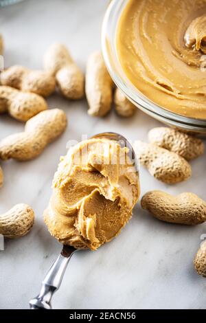 Erdnussbutter auf Löffel und Erdnüsse Stockfoto