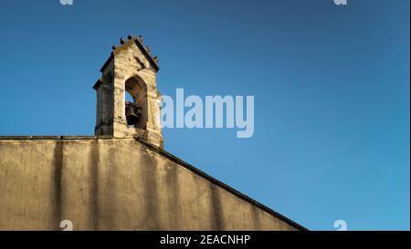 Glockenturm der Kirche Notre Dame in Coursan. Monument historique, das älteste Gebäude im Dorf. Stockfoto