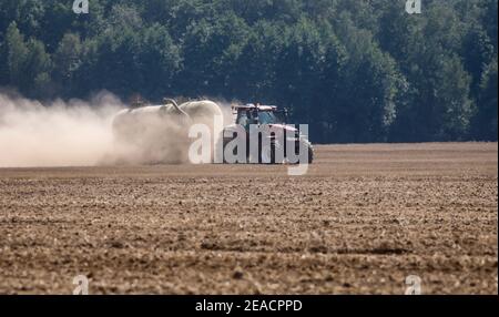 Oberlausitz, Sachsen, Deutschland - staubtrockene Felder im heißen Sommer arbeitet ein Traktor auf den Feldern, wenn er Dünger direkt in den Boden legt. Stockfoto