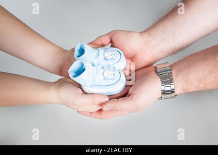 Bauch einer Schwangeren mit Herz aus zwei Paar Händen. Junge weiße Familie wartet auf die Geburt ihres ersten Babys. Schwanger Frau und Mann träumen ein Stockfoto