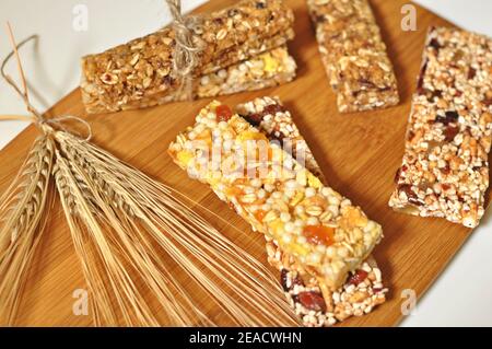 Top-Tabelle der süßen Scheiben von gesunden Müsliriegel mit Getrockneter Weizen und Früchte auf braunem Holztisch Hintergrund Stockfoto