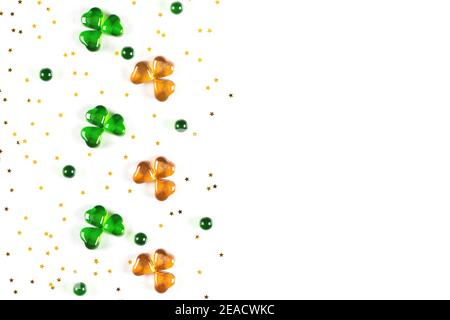 Shamrock Symbole aus grünem und orangefarbenem Glas Herzen auf Weißer Hintergrund Stockfoto