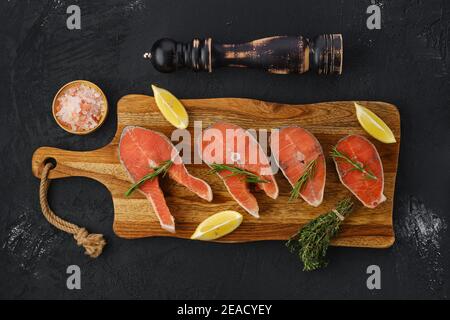 Blick von oben auf rohe Forellensteaks auf Holzschneidebrett Bereit zum Kochen Stockfoto