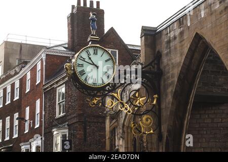 Kleine Admiral-Uhr, die an der Wand am Eingang der Saint Martin Le Grand Church in der Coney Street in York, North Yorkshire, England, Großbritannien hängt. Stockfoto