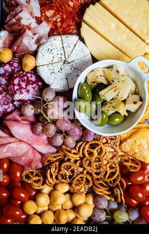Aufschnitt und Käseplatte. Vorspeisen Tablett mit verschiedenen Aufschnitt, Käse, Obst, Oliven und Cracker. Stockfoto
