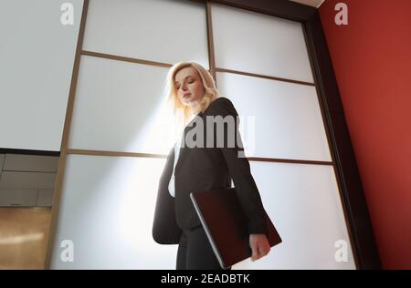 Junge Erwachsene Geschäftsfrau trägt formalwear und trägt den Laptop Stockfoto