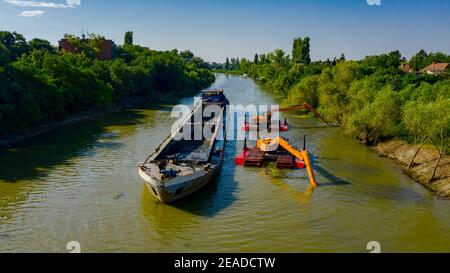 Oben auf zwei Bagger Bagger Baggern, wie sie Baggern, Arbeiten an Fluss, Kanal, Vertiefung und Entfernen von Sediment, Schlamm aus Flussbett in einem verschmutzten Wasser Stockfoto