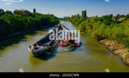 Oben auf zwei Bagger Bagger Baggern, wie sie Baggern, Arbeiten an Fluss, Kanal, Vertiefung und Entfernen von Sediment, Schlamm aus Flussbett in einem verschmutzten Wasser Stockfoto