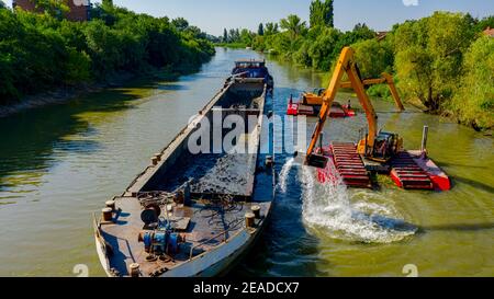 Oben auf zwei Bagger Bagger Baggern, wie sie Baggern, Arbeiten an Fluss, Kanal, Vertiefung und Entfernen von Sediment, Schlamm aus Flussbett in einem verschmutzten Wasser Stockfoto