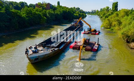 Oben auf zwei Bagger Bagger Baggern, wie sie Baggern, Arbeiten an Fluss, Kanal, Vertiefung und Entfernen von Sediment, Schlamm aus Flussbett in einem verschmutzten Wasser Stockfoto