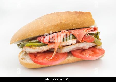 Sandwich Serranito typisch in Andalusien mit Schinken, gren Pfeffer und gegrilltem Schweinefleisch Lende Stockfoto