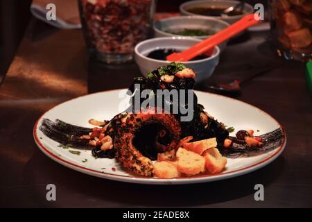 Tagliatelle auf Tintenfisch-Tinte, mit einem einzigartigen schwarzen Caesar's und karamellisierten Oktopus Stockfoto