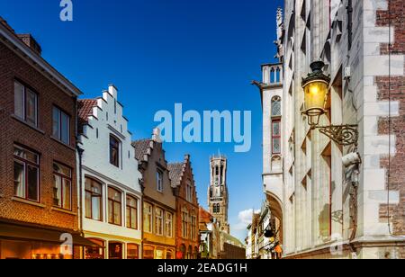 Brügge, Belgien. Stadtbild mit traditionellen Häusern und mittelalterlichen Glockenturm Glockenturm Belfried in der Innenstadt in der Dämmerung. Stockfoto