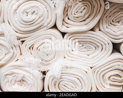Nahaufnahme von vielen stapelbaren weißen Teppichrollen. Stockfoto