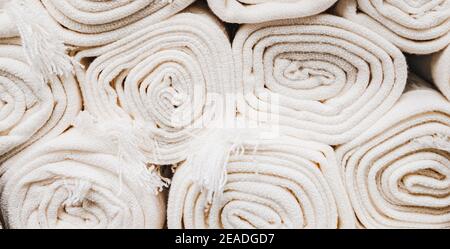 Nahaufnahme von vielen stapelbaren weißen Teppichrollen. Stockfoto