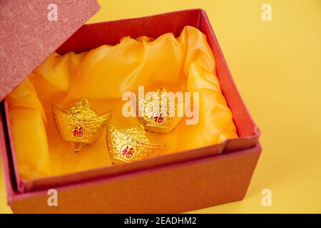 Lunar Neujahrsdekoration mit glücklichen Goldbarren auf gelb isoliert. Tet Holiday.Übersetzung von Text A Stockfoto