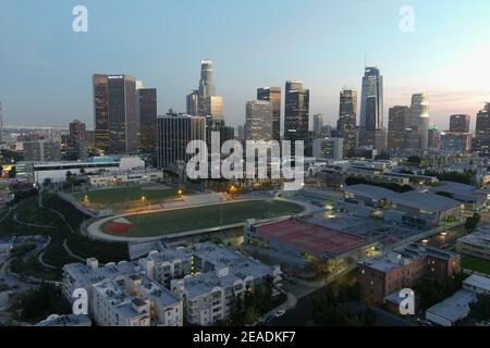 Eine Luftaufnahme des Miguel Contreras Learning Center-Academic Leadership Community High School mit der Innenstadt von Los Angeles Skyline AS Ein Hintergrund o Stockfoto