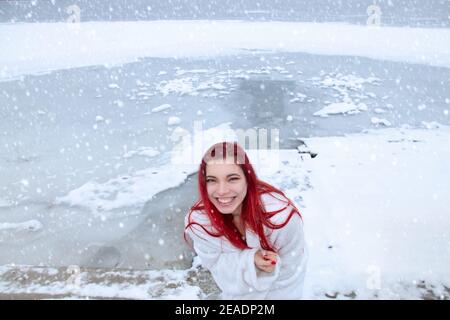 Weibchen nur in einer Decke gewickelt genießt natürliche Kälte-Therapie im Winter im Freien, Verhärtung auf Schnee, Eisbad am natürlichen See in verschneite Natur Stockfoto