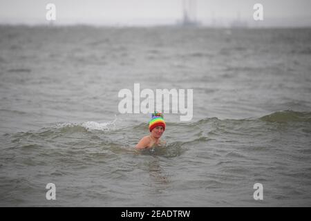 Die frühmorgendliche Schwimmerin Victoria Carlin taucht in Thorpe End, Essex, im 1,4 Grad Celsius warmen Wasser ein, während bitterkalte Winde einen Großteil der Nation weiterhin in den Griff bekommen. Bilddatum: Dienstag, 9. Februar 2021. Stockfoto