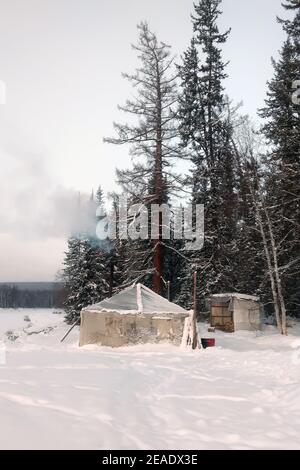 Ein altes Zelt im Schnee. Ein Zelt mit einem Herd im Inneren zwischen der Taiga. Stockfoto