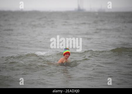 DIE RÜCKÜBERMITTLUNG DES BERICHTIGUNGSSTANDORTES NACH THORPE BAY, ESSEX die frühmorgendliche Schwimmerin Victoria Carlin taucht in Thorpe Bay, Essex, im Wasser, das 1,4 Grad Celsius beträgt, ein, da bitterkalte Winde weiterhin einen Großteil der Nation erreichen. Bilddatum: Dienstag, 9. Februar 2021. Stockfoto