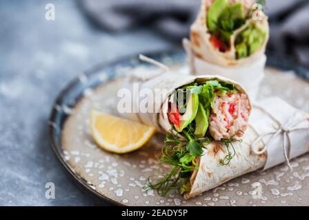 Frische und gesund verpackte Tortilla mit Krabbensalat, Gurke, Avocado, Pfeffer und grünen Kräutern Stockfoto