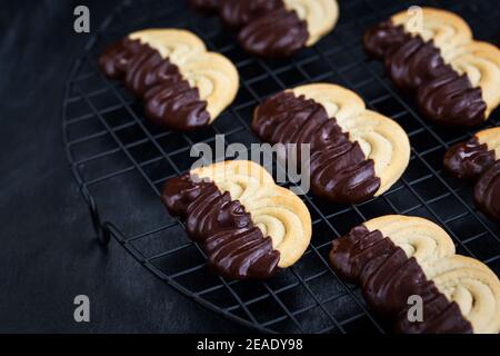 Hausgemachte Schokolade getauchte Shortbread Cookies auf dunklem Hintergrund Stockfoto