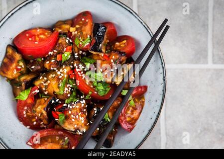 Nahaufnahme von auberginen mit Sesam, Chili und Tomaten, Draufsicht, Kopierbereich Stockfoto