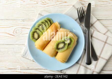 Konzept des Frühstücks mit Teller Crepes Brötchen mit Kiwi Scheiben auf Holztisch Stockfoto