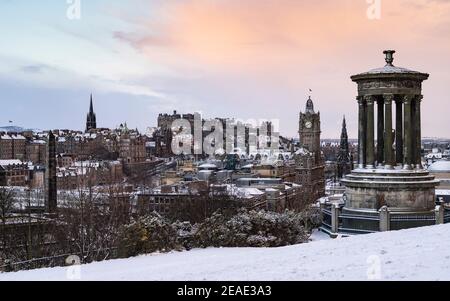 Edinburgh, Schottland, Großbritannien. Februar 2021, 9. Der große Frost geht in Großbritannien weiter, während Storm Darcy über Nacht mehrere Zentimeter Schnee nach Edinburgh bringt. Bild: Schnee flurt bei Sonnenaufgang über der Skyline von Edinburgh von Calton Hill. . Iain Masterton/Alamy Live Nachrichten Stockfoto