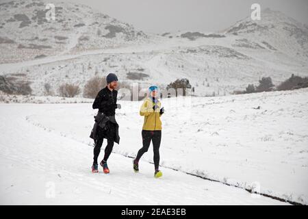 Holyrood Park Edinburgh, Schottland, Großbritannien. 9th. Februar 2021. Der schneebedeckte Holyrood Park ermutigte die Leute, zwischen den Duschen zu spielen und zu trainieren. Stockfoto