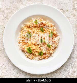Risotto mit Parmesan auf weißem Restaurantteller, Draufsicht Stockfoto