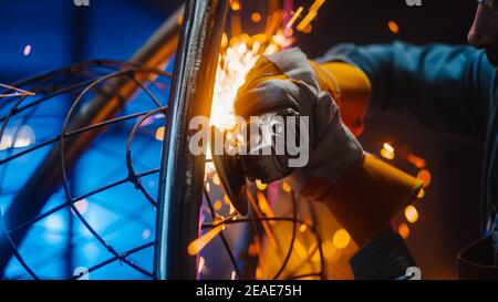Nahaufnahme eines talentierten innovativen Künstlers mit einem Angle Grinder, um eine abstrakte, brutale und ausdrucksstarke Metallskulptur in einem Workshop zu machen. Modern Stockfoto