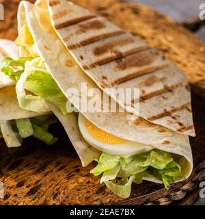 Gesunde hausgemachte Tortilla Wrap mit frisch zubereitetem grünen Caesar Salat Stockfoto