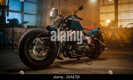 Custom Bobber Motorrad stehen in einem authentischen kreativen Workshop. Vintage Style Motorrad unter warmen Lampe Licht in einer Garage. Stockfoto