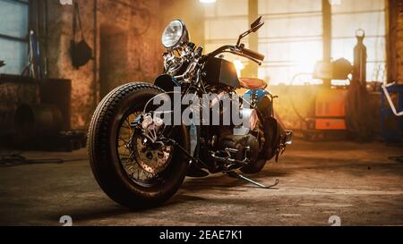 Custom Bobber Motorrad stehen in einem authentischen kreativen Workshop. Vintage Style Motorrad unter warmen Lampe Licht in einer Garage. Stockfoto