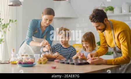 In der Küche: Familie von vier Kochen Muffins zusammen. Mutter und Tochter Mischen Mehl und Wasser zu Teig für Cupcakes, Vater, Sohn zu erstellen Stockfoto