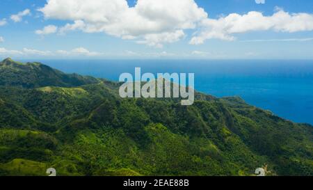 Berglandschaft auf tropischer Insel mit blauem Meer, Berggipfel mit Wald bedeckt. Berghänge mit immergrüner Vegetation. Philippinen, Mindanao Stockfoto