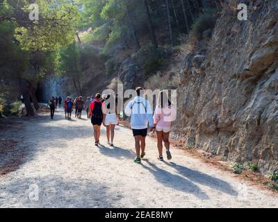 Gruppe von Wanderern auf einem Weg zwischen den Bergen des Naturparks der Gaitanes-Schlucht in Malaga, an einem sonnigen Tag. Stockfoto