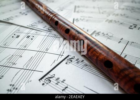 Vintage braune Flöte mit Mustern, auf weißen Noten mit Noten. Stockfoto