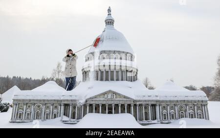 Sachsen, Lichtenstein/Sachsen,09. Februar 2021: Ein Mitarbeiter räumt Schnee aus dem Washington DC Capitol in Miniworld. Um Schäden im Winter zu vermeiden, sind einige der Denkmäler eingezäunt. Der Rest wird regelmäßig kontrolliert und von Schnee befreit. Die Schneelast und vor allem der Wechsel zwischen Tauwetter und Frost ist ein Problem. Wasser dringt zwischen die filigranen Steine ein und bläst sie ab. Im Vergnügungspark befinden sich über 100 weltberühmte Denkmäler im Maßstab 1:25. Fast 2 Millionen Menschen haben die Mini-Welt bereits besucht. Foto: Jan Woitas/dpa-Zentralbild/dpa Quelle: dpa picture Alliance/Alam Stockfoto