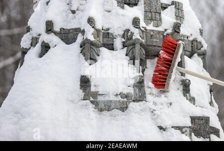 Sachsen, Lichtenstein/Sachsen,09. Februar 2021: Ein Mitarbeiter entfernt Schnee aus dem Völkerschlachtdenkmal in der Miniwelt. Um Schäden im Winter zu vermeiden, sind einige der Denkmäler eingezäunt. Die anderen werden regelmäßig kontrolliert und von Schnee befreit. Die Schneelast und vor allem der Wechsel zwischen Tauwetter und Frost ist ein Problem. Wasser dringt zwischen die filigranen Steine ein und bläst sie ab. Im Vergnügungspark befinden sich über 100 weltberühmte Denkmäler im Maßstab 1:25. Fast 2 Millionen Menschen haben die Mini-Welt bereits besucht. Foto: Jan Woitas/dpa-Zentralbild/dpa Kredit: dpa pic Stockfoto