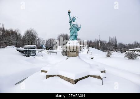 Sachsen, Lichtenstein/Sachsen,09. Februar 2021: Die Freiheitsstatue steht als schneebedecktes Modell in der Miniwelt. Um Schäden im Winter zu vermeiden, sind ein Teil der Denkmäler eingeschlossen. Die anderen werden regelmäßig kontrolliert und von Schnee befreit. Die Schneelast und vor allem der Wechsel zwischen Tauwetter und Frost sind ein Problem. Wasser dringt zwischen die filigranen Steine ein und bläst sie ab. Im Vergnügungspark befinden sich über 100 weltberühmte Denkmäler im Maßstab 1:25. Fast 2 Millionen Menschen haben die Mini-Welt bereits besucht. Foto: Jan Woitas/dpa-Zentralbild/dpa Quelle: dpa picture Alliance/Alamy Stockfoto