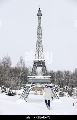 Sachsen, Lichtenstein/Sachsen,09. Februar 2021: Ein Mitarbeiter spaziert mit Schneebesen und Schneeschaufel zum Eiffelturm in der Miniworld. Um Schäden im Winter zu vermeiden, sind einige der Denkmäler eingezäunt. Die anderen werden regelmäßig kontrolliert und von Schnee befreit. Die Schneelast und vor allem der Wechsel zwischen Tauwetter und Frost ist ein Problem. Wasser dringt zwischen die filigranen Steine ein und bläst sie ab. Im Vergnügungspark befinden sich über 100 weltberühmte Denkmäler im Maßstab 1:25. Fast 2 Millionen Menschen haben die Mini-Welt bereits besucht. Foto: Jan Woitas/dpa-Zentralbild/dpa Kredit: dpa Bild Stockfoto